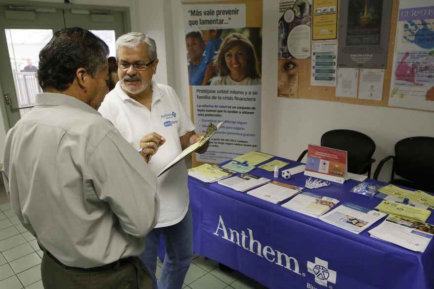 In this Oct. 1, 2013, file photo, Alberto Pizon, right, a representative of Anthem BlueCross BlueShield Latino Health Access group provides free information to Paulino Zarate, 65, left, on the new health options available during a health fair promoted at the Binational Health Week event held at the Mexican Consulate in Los Angeles. (AP Photo/Damian Dovarganes, File)