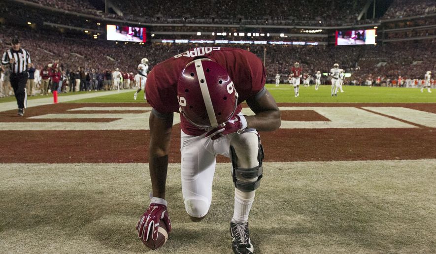 In this file photo, Alabama wide receiver Amari Cooper kneels in prayer in the back of the end zone after catching a long touchdown pass against Auburn Saturday, Nov. 29, 2014, in Tuscaloosa, Ala. Inspired by a 2022 Supreme Court prayer ruling, a Christian school in Florida is arguing for its right to air prayers on the loudspeaker at state championship sports events.  (AP Photo/Decatur Daily, Gary Cosby)  **FILE**