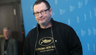 Director Lars von Trier reveals a tee shirt which has the Cannes film festival symbol and the slogan Persona Non Grata underneath as he poses for photographers at the photo call for the film Nymphomaniac at the International Film Festival Berlinale in Berlin, Sunday, Feb. 9, 2014. In 2011 Von Trier was asked to leave the Cannes film festival after a bizarre, rambling news conference in which he said he sympathizes with Adolf Hitler. (Photo by Joel Ryan/Invision/AP)