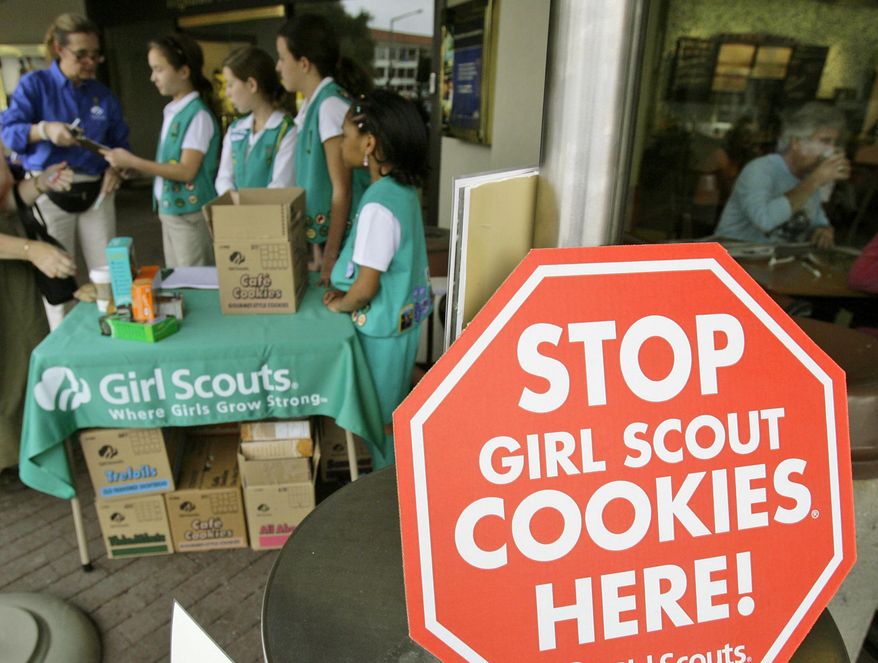 In this Feb. 23, 2007 file photo, Girl Scouts from the Texas Council sell cookies in Dallas. On May 1, 2017, Archbishop Joseph F. Naumann of the Catholic Archdiocese of Kansas City in Kansas announced that parishes in his jurisdiction shall sever their ties with the Girl Scouts and may pursue the Christian alternative American Heritage Girls instead. (AP Photo/Matt Slocum, File) **FILE**