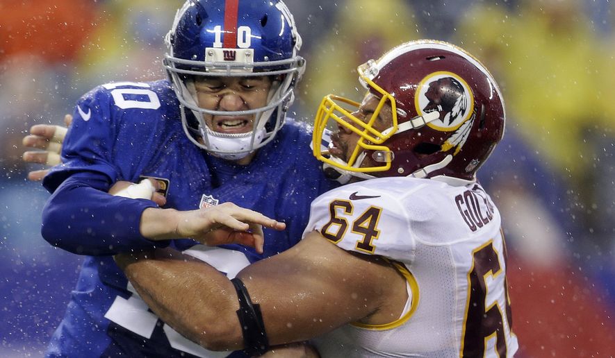 Washington Redskins defensive end Kedric Golston (64) hits New York Giants&#39; Eli Manning (10) who throws a pass during the first half of an NFL football game on Sunday, Dec. 29, 2013, in East Rutherford, N.J.  (AP Photo/Julio Cortez)