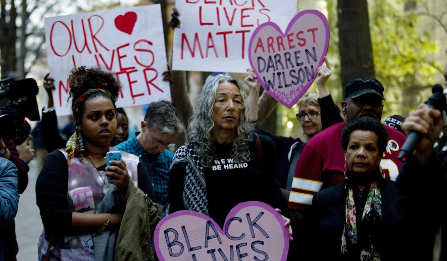 Demonstrators protest against the shooting of unarmed 18-year-old Michael Brown, during a rally at the Department of Justice in Washington, Monday, Dec. 1, 2014. A grand jury in Ferguson, Mo., on Monday, Nov. 24, 2014, declined to indict police officer Darren Wilson in the shooting death of Brown, an unarmed black man. Protesters across the U.S. have walked off their jobs or away from classes in support of the Ferguson protesters. Monday&#39;s walkouts stretched from New York to San Francisco, and included Chicago and Washington, D.C.  (AP Photo/Jose Luis Magana)