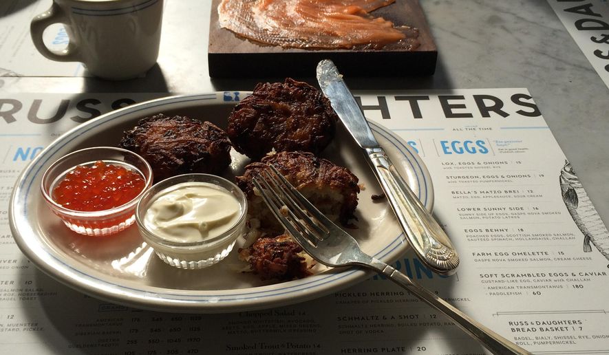 This 2014 photo provided by Russ & Daughters shows latkes, which are potato pancakes traditionally served at Hanukkah, at Russ & Daughters Cafe on the Lower East Side of New York City. Russ & Daughters’ take-out business, founded in 1914, sells traditional Jewish foods to go like smoked fish and chopped liver from a shop nearby. The family’s fourth generation opened the cafe earlier this year with a sit-down menu. (AP Photo/Russ & Daughters, Jen Snow and Kelli Anderson)