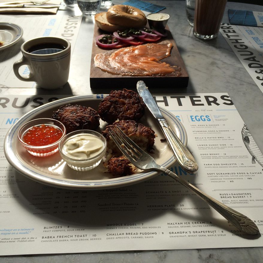 This 2014 photo provided by Russ & Daughters shows latkes, which are potato pancakes traditionally served at Hanukkah, at Russ & Daughters Cafe on the Lower East Side of New York City. Russ & Daughters’ take-out business, founded in 1914, sells traditional Jewish foods to go like smoked fish and chopped liver from a shop nearby. The family’s fourth generation opened the cafe earlier this year with a sit-down menu. (AP Photo/Russ & Daughters, Jen Snow and Kelli Anderson)