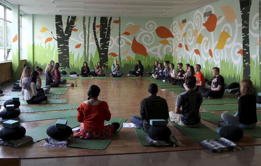 In this Oct. 1, 2014 file photo, students meditate during Mindful Studies class at Wilson High School in Portland, Ore. College students on some campuses are investigating meditation as well. (AP Photo/Gosia Wozniacka)