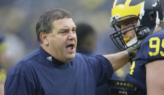 Michigan head coach Brady Hoke talks with defensive tackle Matthew Godin during warmups before the NCAA college football game against Maryland in Ann Arbor, Mich., Saturday, Nov. 22, 2014. (AP Photo/Carlos Osorio)