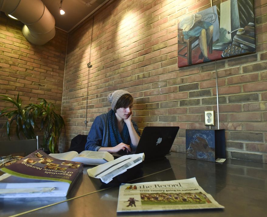 In this Tuesday, Dec. 2, 2014 photo, Nursing major Irene Schmid of Kidron, Ohio works on a presentation for class at the Java Junction on the campus of Goshen College in Goshen, Ind. Goshen College received a $1.98 million donation from former student Milo Albrecht, who is 93. The money will be used for scholarships, primarily for nursing students. (AP Photo/The Elkhart Truth, Jennifer Shephard)