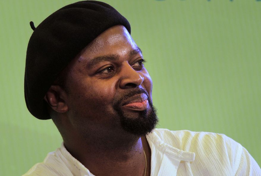 FILE - This is a Saturday, Jan. 21, 2012 file photo of Booker Prize winning Nigerian author Ben Okri smiles as he talks about his novel "Famished Road" during the Jaipur Literature Festival, in Jaipur, in the western Indian state of Rajasthan, India. Booker Prize-winning Nigerian writer Ben Okri has won the uncoveted Bad Sex in Fiction Award, a prize for erotic literary encounters that push all the wrong buttons. The writer took the tongue-in-cheek honor Wednesday Dec. 3, 2014 for conjuring an over-the-top passage in his novel "The Age of Magic." "The universe was in her and with each movement it unfolded to her," Okri wrote. "Somewhere in the night a stray rocket went off." (AP Photo/Manish Swarup, File)
