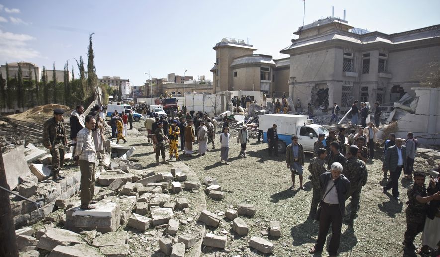 Security forces and civilians gather at the damaged residence of the Iranian ambassador after a car bomb attack in Sanaa, Yemen, Wednesday, Dec. 3, 2014. A massive car bomb exploded Wednesday morning in the Yemeni capital, Sanaa, apparently targeting the home of the Iranian ambassador, Yemeni security officials said. (AP Photo/Hani Mohammed)