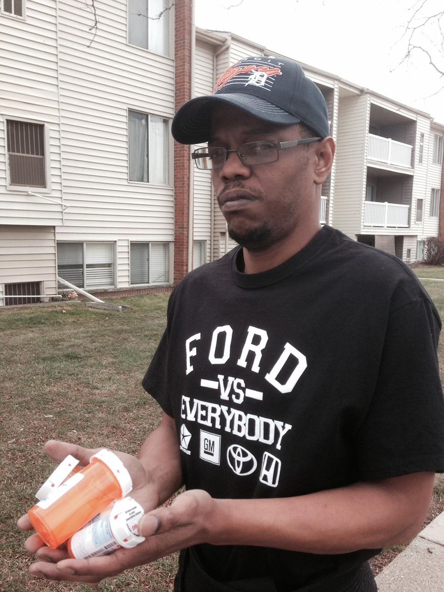 In a photo from Dec. 3, 2014, Tonocca Scott, 40, of Ypsilanti, Mich., stands outside his apartment building with prescription drugs for back pain. Scott blames Dr. Aria Sabit for a botched back surgery. The Detroit-area doctor is charged in federal court with fraud. He's accused of billing insurers for wrong procedures and misleading patients about how he planned to fix their spines. He surrendered his California medical license earlier this year. (AP Photo/Ed White)