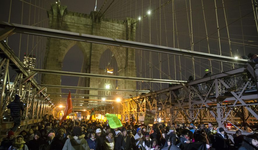 Demonstrators march across the Brooklyn Bridge during a protest against a grand jury's decision not to indict the police officer involved in the death of Eric Garner, Thursday, Dec. 4, 2014, in New York. A grand jury cleared a white New York City police officer Wednesday in the videotaped chokehold death of Garner, an unarmed black man, who had been stopped on suspicion of selling loose, untaxed cigarettes. (AP Photo/John Minchillo)
