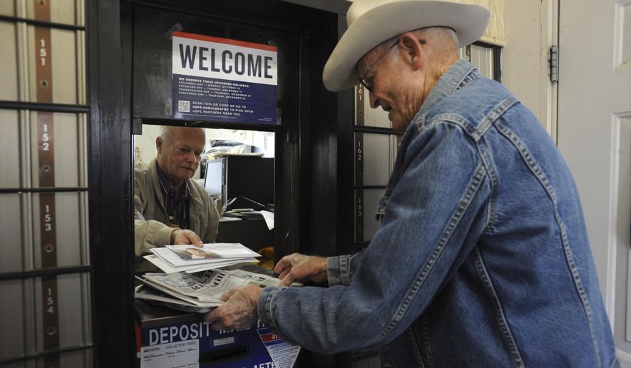 Jackie Skiles, 83, picks up his mail from postmaster Neal Wellman in Langtry, Texas, on Friday, Nov. 21, 2014. Skiles is one of the very residents still living in Langtry. Once a bustling railroad and ranching hub an hour west of Del Rio, Langtry now is little more than a collection of empty homes and crumbling ruins, reduced to five families, a highway gas station and the state visitors center. (AP Photo/The San Antonio Express-News, Billy Calzada) RUMBO DE SAN ANTONIO OUT; NO SALES