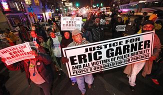 Illuminated by red police siren lights, people march on Broad St. in Newark, N.J. to protest police brutality and the previous day&#39;s decision to not indict the New York City police officer involved in the death of Eric Garner in Staten Island on Thursday, Dec. 4, 2014. (AP Photo/The Record of Bergen County - Northjersey.com, Kevin R. Wexler)