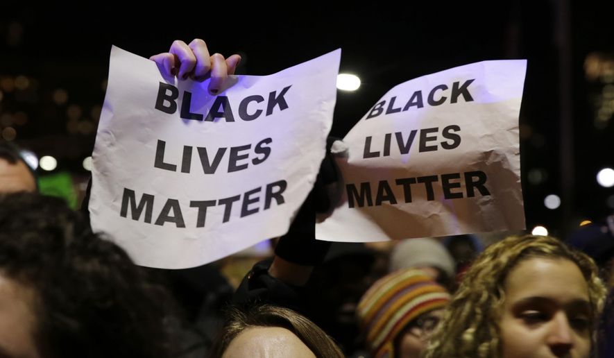 In this Dec. 4, 2014 file photo, protestors in Boston hold up signs while chanting &quot;Black Lives Matter&quot; during a demonstration against the deaths of two unarmed black men at the hands of white police officers in New York City and Ferguson, Mo. (AP Photo/Charles Krupa, file) ** FILE **
