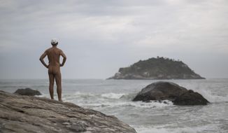Pedro Ribeiro looks out at the sea from  Abrico beach, recently designated as nudist after a 20-year-battle, in Rio de Janeiro, Brazil, Thursday, Dec. 4, 2014. The law passed last month frees nudists from any threat of legal action and provides increased protection, including patrols to keep peeping Toms away. (AP Photo/Felipe Dana)