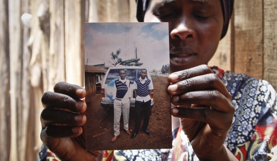 In this May 9, 2014 photo, Saida Mohammed Kaburu displays a photograph of her son Mohamed Kaburu, as she speaks to The Associated Press in Nyeri, Kenya. Mohamed Kaburu&#39;s body and those of four of his friends were discovered April 17 with bullet holes in their heads deep in a forest near the central Kenyan town of Nyeri. The last time the five were seen was in police custody according to their families. (AP Photo/Khalil Senosi)