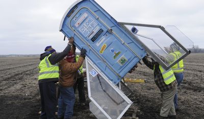 Members of the Michiana Rocketry prep a 10-foot, 450 pound porta-potty, mounted on rocket motors for launching, Saturday, Dec. 6, 2014, from a field in Three Oaks, Mich.(AP Photo/The Herald-Palladium, Don Campbell)