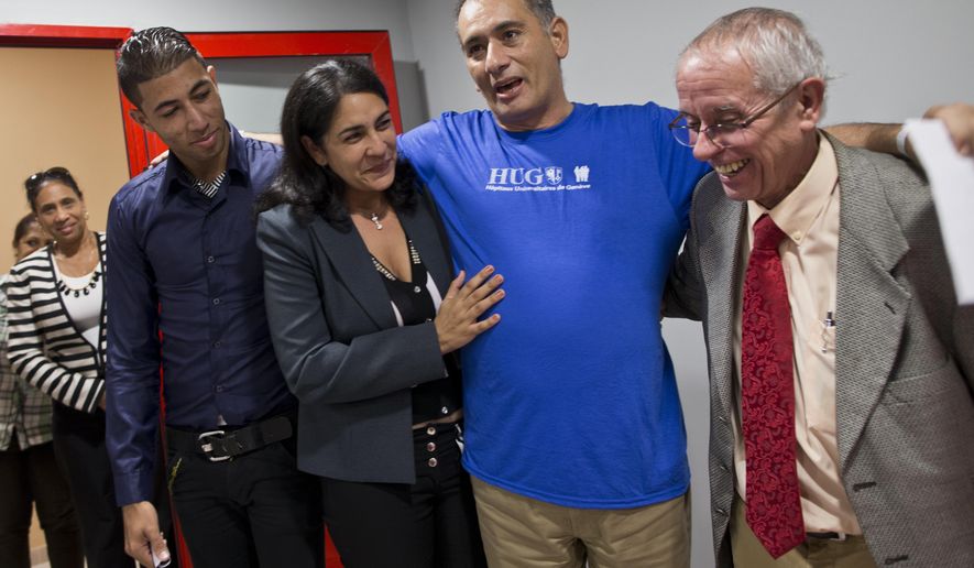 Cuban doctor Felix Baez Sarria, who contracted Ebola while on an aid mission in Sierra Leona, second from right, smiles as he poses for photos with his wife Vania Ferre, son Alejandro Felix, left, and Dr. Jorge Perez upon arrival to Havana, Cuba, Saturday, Dec. 6, 2014. Baez, 43, is among 165 Cuban medical personnel sent to Sierra Leone to fight the disease. He showed symptoms of Ebola on Nov. 16 and was brought to Switzerland for treatment with the experimental drug ZMapp. (AP Photo/Ramon Espinosa, Pool)