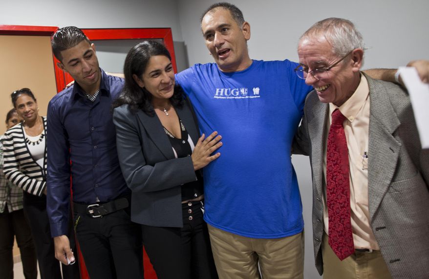 Cuban doctor Felix Baez Sarria, who contracted Ebola while on an aid mission in Sierra Leona, second from right, smiles as he poses for photos with his wife Vania Ferre, son Alejandro Felix, left, and Dr. Jorge Perez upon arrival to Havana, Cuba, Saturday, Dec. 6, 2014. Baez, 43, is among 165 Cuban medical personnel sent to Sierra Leone to fight the disease. He showed symptoms of Ebola on Nov. 16 and was brought to Switzerland for treatment with the experimental drug ZMapp. (AP Photo/Ramon Espinosa, Pool)