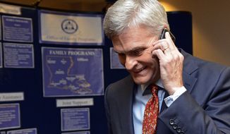 Louisiana Senatorial Candidate, Bill Cassidy, takes a call while going to meet supporters at his election watch party in Baton Rouge, La., Saturday, Dec. 6, 2014. (AP Photo/Bill Feig)