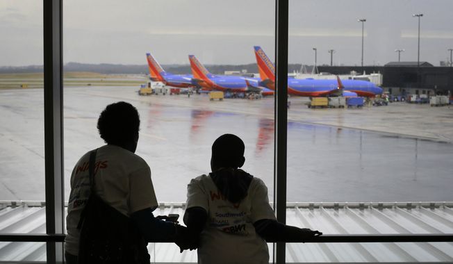 Malkia Wageed, left, looks at airplanes with her son, Tylee Lynn, 12, at Baltimore-Washington International Thurgood Marshall Airport, Saturday, Dec. 6, 2014, in Linthicum, Md., while they participate in Wings for Autism, an airport rehearsal for children with autism spectrum disorders, their families and aviation officials. (AP Photo/Patrick Semansky) ** FILE **
