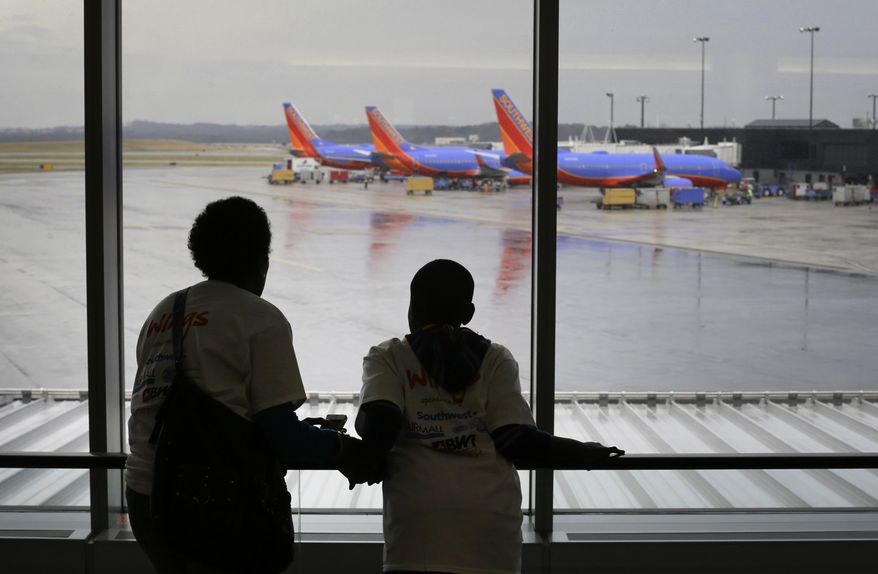 Malkia Wageed, left, looks at airplanes with her son, Tylee Lynn, 12, at Baltimore-Washington International Thurgood Marshall Airport, Saturday, Dec. 6, 2014, in Linthicum, Md., while they participate in Wings for Autism, an airport rehearsal for children with autism spectrum disorders, their families and aviation officials. (AP Photo/Patrick Semansky) ** FILE **