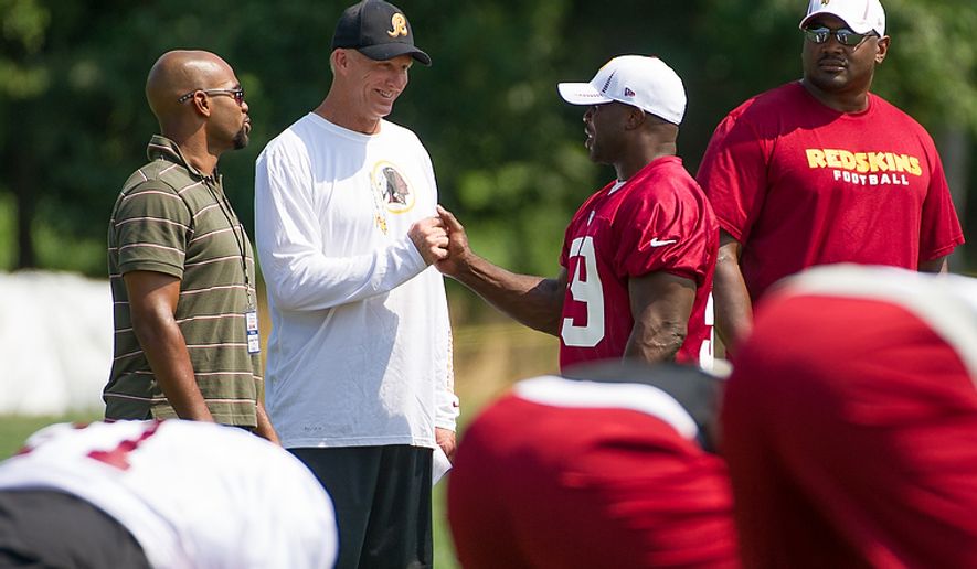 Washington Redskins defensive coordinator Jim Haslett, second from left, talks with Washington Redskins linebacker London Fletcher (59), second from right, during afternoon practice at training camp at Redskins Park, Ashburn, Va., Wednesday, August 1, 2012. (Andrew Harnik/The Washington Times)