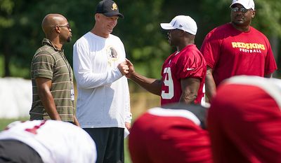 Washington Redskins defensive coordinator Jim Haslett, second from left, talks with Washington Redskins linebacker London Fletcher (59), second from right, during afternoon practice at training camp at Redskins Park, Ashburn, Va., Wednesday, August 1, 2012. (Andrew Harnik/The Washington Times)