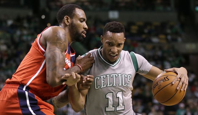 Boston Celtics guard Evan Turner, right, tries to drive past Washington Wizards forward Rasual Butler, left, in the second quarter of an NBA basketball game, Sunday, Dec. 7, 2014, in Boston. (AP Photo/Steven Senne)
