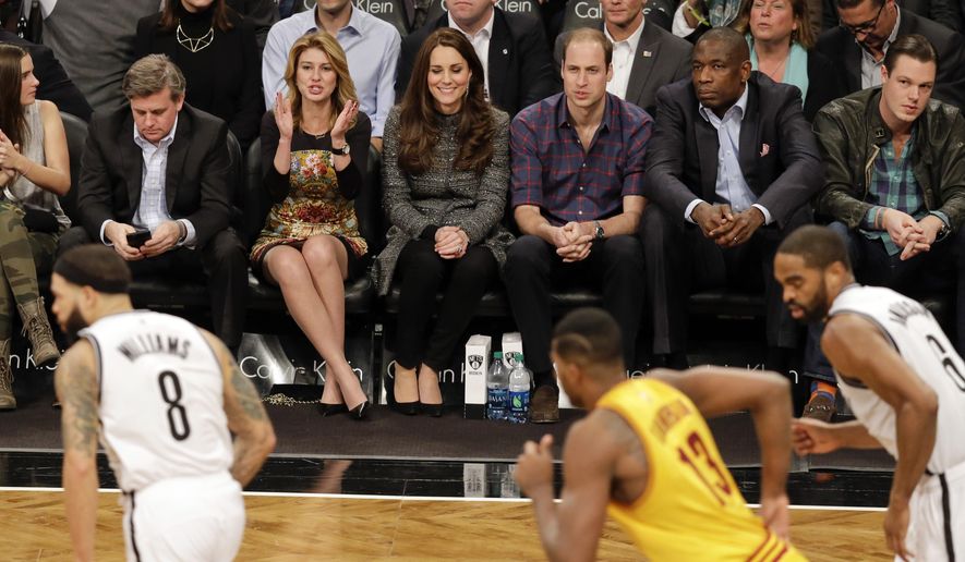 Britain's Prince William, third from right, and Kate, Duchess of Cambridge, sit with former Houston Rockets player Dikembe Mutombo, second from right, during the second half of an NBA basketball game between the Brooklyn Nets and the Cleveland Cavaliers, Monday, Dec. 8, 2014, in New York. (AP Photo/Frank Franklin II)