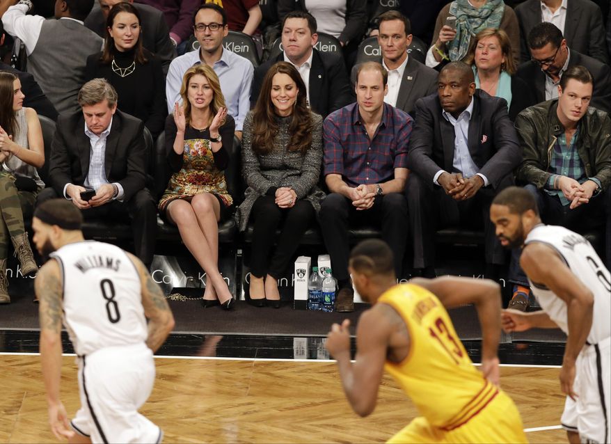 Britain's Prince William, third from right, and Kate, Duchess of Cambridge, sit with former Houston Rockets player Dikembe Mutombo, second from right, during the second half of an NBA basketball game between the Brooklyn Nets and the Cleveland Cavaliers, Monday, Dec. 8, 2014, in New York. (AP Photo/Frank Franklin II)