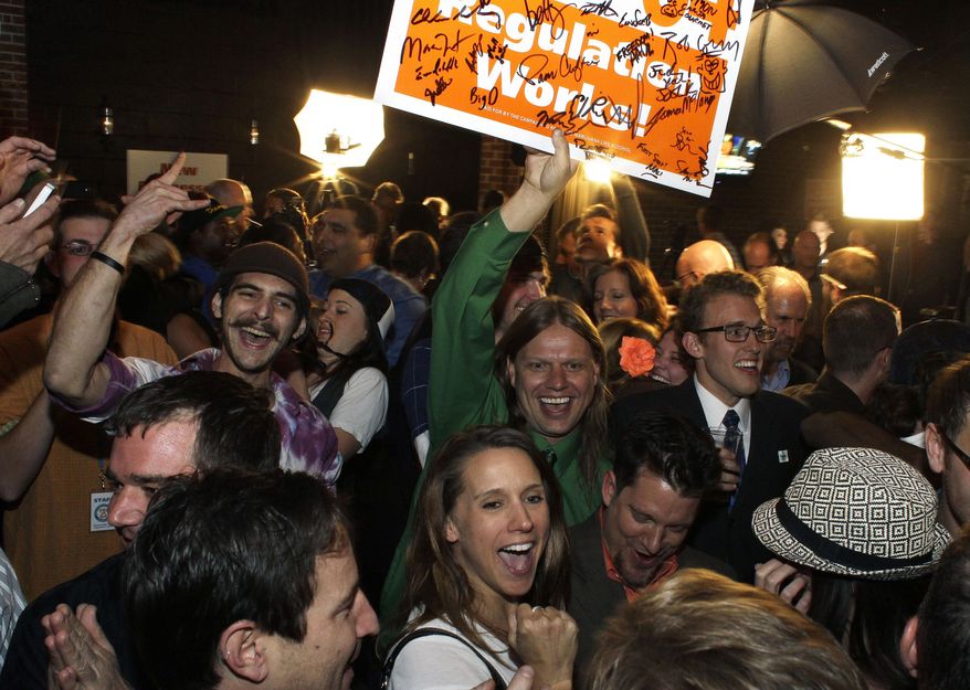 FILE - In this Nov. 6, 2012 file photo, people attending an Amendment 64 watch party celebrate after a local television station announced the marijuana amendment's passage in Denver, Colo. Colorado is marking two years since recreational marijuana became legal for adults over 21. Amendment 64 passed in November of 2012, but it wasn’t until Dec. 10 that Gov. John Hickenlooper formalized it as part of the state constitution. (AP Photo/Brennan Linsley, file)