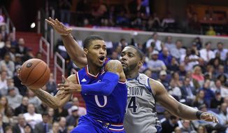 Kansas guard Frank Mason III (0) passes the ball against Georgetown center Joshua Smith (24) during the first half of an NCAA college basketball game, Wednesday, Dec. 10, 2014, in Washington. (AP Photo/Nick Wass)