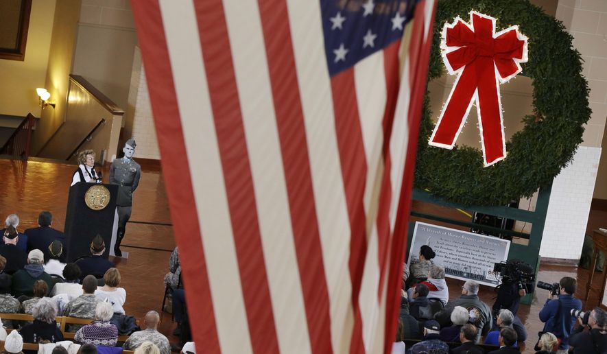 Edith T. Nowels, left at podium, of Brielle, N.J., stands next to a life-size cut-out of her brother, Medal of Honor Recipient U.S.Army Cpl. Horace Marvin Thorne, as she praises his action in World War II during the Battle of the Bulge, during a Wreaths Across America ceremony on Ellis Island Wednesday, Dec. 10, 2014, in Jersey City, N.J. (AP Photo/Mel Evans)