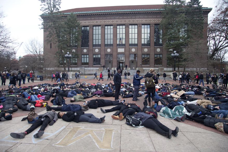 University of Michigan students lay on the ground during a protest of the killing of unarmed black men by white police, at the University of Michigan in Ann Arbor, Mich., on Wednesday, Dec. 10, 2014. (AP Photo/The Ann Arbor News, Patrick Record)