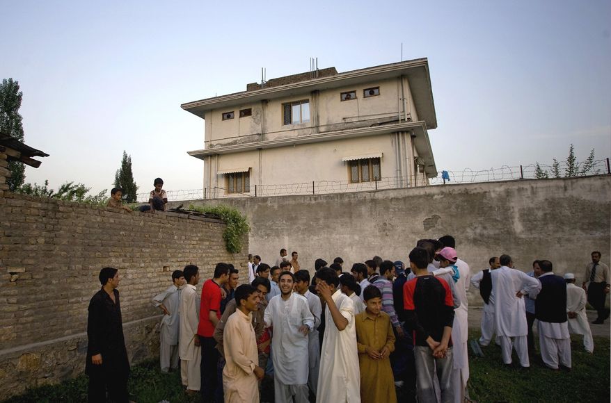 FILE - In this May 3, 2011 file photo, local residents gather outside a house, where al-Qaida leader Osama bin Laden was caught and killed in Abbottabad, Pakistan. After U.S. Navy SEALs killed Osama bin laden in Pakistan in May 2011, top CIA officials secretly told lawmakers that information gleaned from brutal interrogations played a key role in what was one of the spy agency’s greatest successes. CIA director Leon Panetta repeated that assertion in public, and it found its way into a critically acclaimed movie about the operation, Zero Dark Thirty, which depicts a detainee offering up the identity of bin Laden’s courier, Abu Ahmad al- Kuwaiti, after being tortured at a CIA “black site.” As it turned out, Bin Laden was living in al Kuwaiti’s walled family compound, so tracking the courier was the key to finding the al-Qaida leader.    (AP Photo/B.K.Bangash,File)