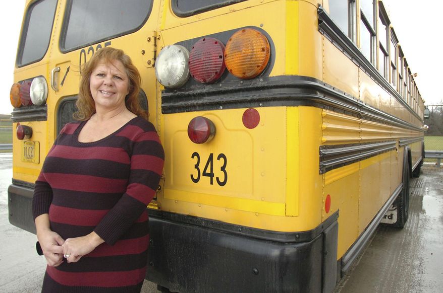 ADVANCE FOR MONDAY DEC. 15 AND THEREAFTER - In a Nov. 24, 2014 photo, Rhonda Rayford poses for a photo with a school bus like the one she drives in Fort Wayne, Ind. When things get too quiet on Rayford's bus, she tells her young riders to start making some noise. The bus ride to and from school is the time to let off steam, and if her kids aren't singing and carrying on, then it's not good, said Rayford, who goes by Miss Rhonda when she is driving. (AP Photo/The Journal-Gazette, Samuel Hoffman) NEWS-SENTINEL OUT; MANDATORY CREDIT; NO SALES; MAGS OUT