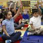 Ella Perez, left, and Christian Sliva-Pedroz raise their hands to answer a question as student teacher Josh Wieder reads to the students in Bethany Farrell&#39;s kindergarten class on Nov. 5, 2014, at Miller Elementary School in Lafayette, Ind. (AP Photo/Journal &amp;amp; Courier, John Terhune) ** FILE **