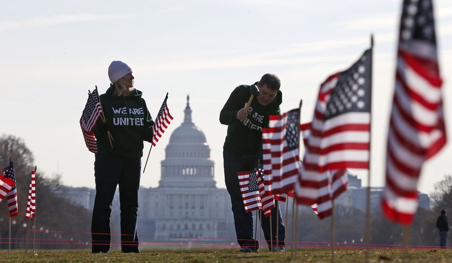 With the Capitol in the background, Army veteran David Dickerson of Oklahoma City, Okla., right, and Air Force veteran Linda Stanley, from San Diego, Calif., now with Iraq and Afghanistan Veterans of America (IAVA), join others to place 1,892 flags representing veteran and service members who have died by suicide to date in 2014, Thursday, March 27, 2014, on the National Mall in Washington. The event also marked the introduction of The Suicide Prevention for America&#39;s Veterans Act by Sen. John Walsh, D-Mont., which calls for greater access to mental health care. (AP Photo/Charles Dharapak) **FILE**