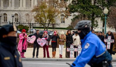 Members of the protest group Code Pink and mothers of children of police brutality show their support as African American Congressional staffers hold a protest nearby on the House steps of the U.S. Capitol Building to protest the Eric Garner and Mike Brown grand jury decisions, Washington, D.C., Thursday, December 11, 2014. (Andrew Harnik/The Washington Times)