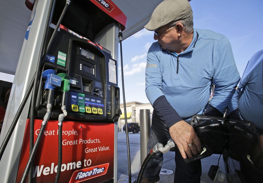 Eduardo Palacios-Paez, of Miami, pumps gas at a RaceTrac gasoline station, Thursday, Dec. 11, 2014, in Hialeah, Fla. Motorists are now seeing prices under $3 a gallon for the first time in four years, which also means that gas stations are paying less for the fuel, too. (AP Photo/Wilfredo Lee)