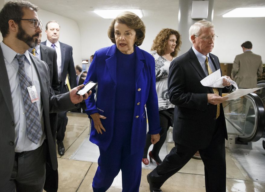 Senate Intelligence Committee Chair Sen. Dianne Feinstein, D-Calif., center, and Sen. Roger Wicker, R-Miss., right, rush to the Senate floor on Capitol Hill in Washington, Thursday, Dec. 11, 2014, for a procedural vote to advance the $585 billion defense bill. Earlier this week, Feinstein released a report on the CIA's harsh interrogation techniques at secret overseas facilities after the 9/11 terror attacks. (AP Photo/J. Scott Applewhite)