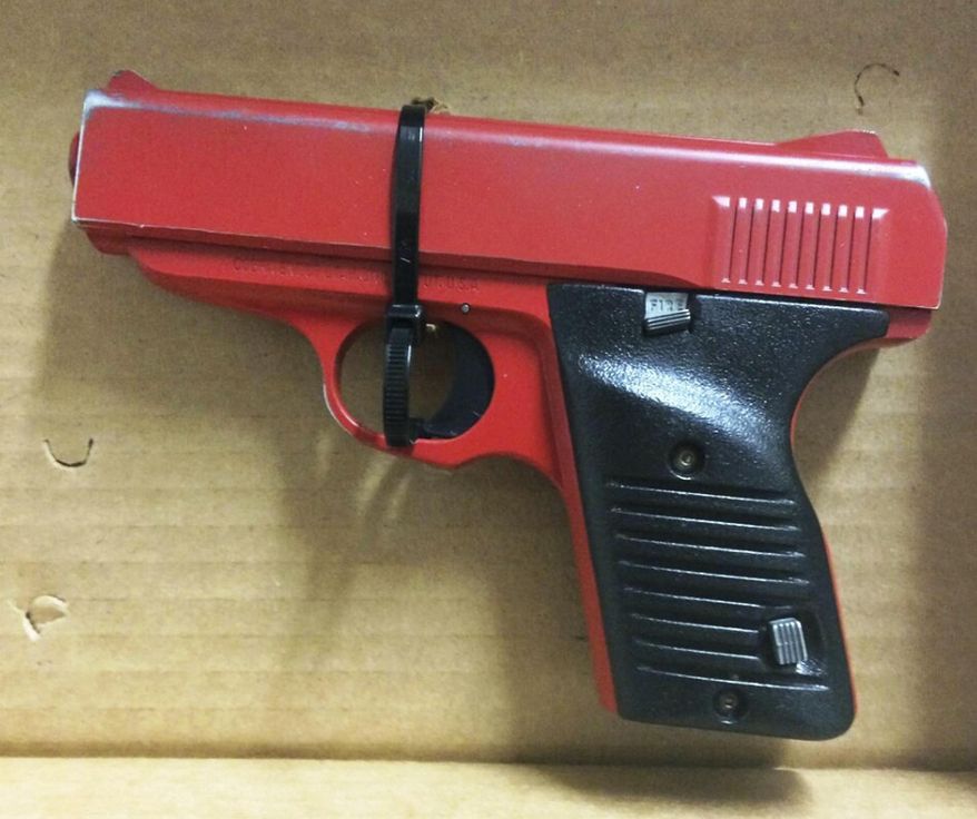 This photo provided by the Hamilton County Sheriff in Cincinnati shows a red-painted, 380-caliber handgun police found during the arrest of 23-year-old Orlando Lowery when responding to a call about a man with a gun. The arrest Friday, Dec. 12, 2014, came just four days after legislation was introduced in Ohio to require that lookalike guns be brightly colored or otherwise marked. (AP Photo/Hamilton County Sheriff)