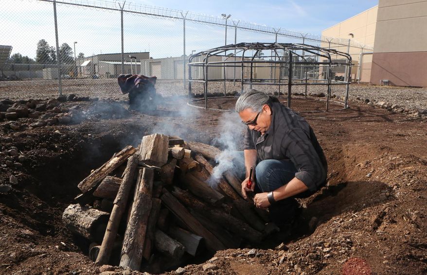 FILE - In this Dec. 17, 2009 file photo, Shannon Rivers prepares a fire to heat rocks which will be used in a sweat lodge-like purification ceremony for inmates at the Coconino County jail in Flagstaff, Ariz. The jail where approximately half the inmate population is Native American is allowing traditional sweat lodge ceremonies after a seven-year hiatus.(AP Photo/The Arizona Daily Sun, Jake Bacon)
