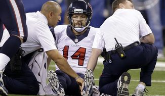 Houston Texans quarterback Ryan Fitzpatrick (14) is treated on the field after being injured during the first half of an NFL football game against the Indianapolis Colts in Indianapolis, Sunday, Dec. 14, 2014. (AP Photo/Darron Cummings)