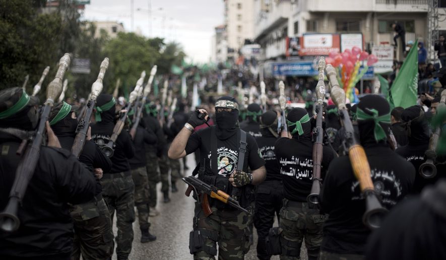 Palestinian Hamas masked gunmen march in a rally to commemorate the 27th anniversary of the Hamas militant group, in Gaza City, Sunday, Dec. 14, 2014. (AP Photo/Khalil Hamra)
