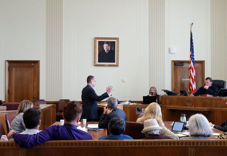 FILE - In this Thursday, Sept. 25, 2014 file photo, same-sex couples, plaintiffs in a class-action lawsuit against the state of Missouri, foreground, watch as Anthony Rothert, legal director of the American Civil Liberties Union of Missouri argues before Circuit Court Judge J. Dale Youngs during a hearing in Kansas City, Mo. American Civil Liberties Union officials say they have begun a new and more aggressive effort to intervene in Missouri and Kansas over highly public issues like same-sex marriage, privacy and police policy. (AP Photo/St. Louis Post-Dispatch, Christian Gooden, Pool, File)