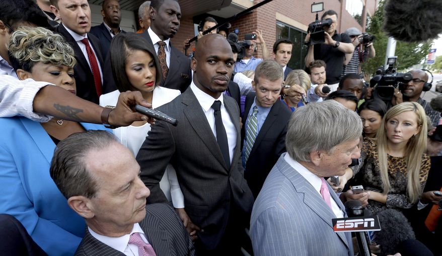 FILE - In this Oct. 8, 2014, file photo, Minnesota Vikings running back Adrian Peterson, center, stands with his wife Ashley Brown Peterson, center left, and mother Bonita Jackson, far left, as they listen to Peterson's attorney Rusty Hardin, right, outside the courthouse after making his first court appearance in Conroe, Texas. The NFL Players Association filed a federal lawsuit Monday, Dec. 15, 2014, for Adrian Peterson, asking the court to dismiss an arbitration ruling that upheld the NFL's suspension of the star running back. (AP Photo/David J. Phillip, Pool File)