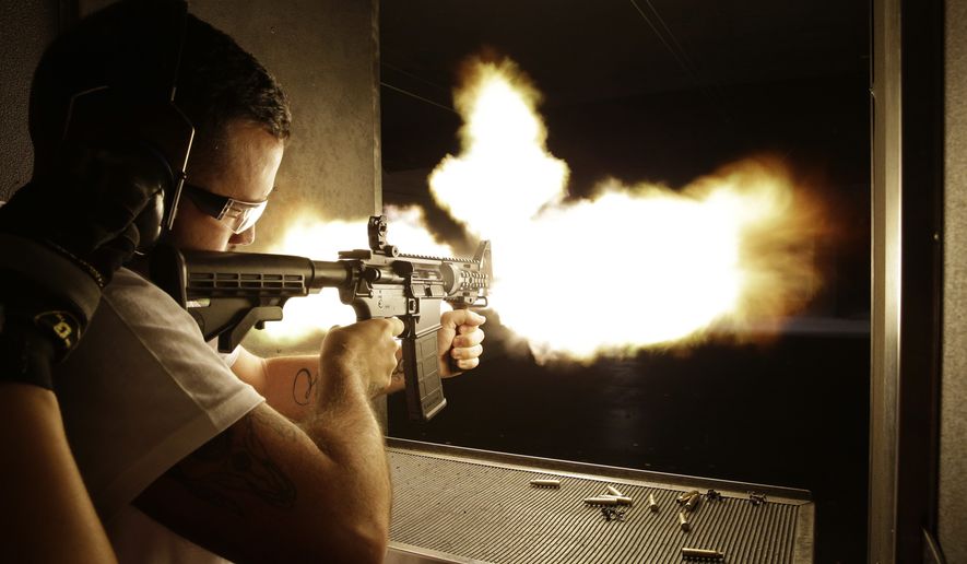 Brad Whitehead of Manchester, England fires a fully automatic machine gun at Machine Guns Vegas Thursday, Aug. 28, 2014, in Las Vegas. Most visitors to Machine Guns Vegas have already pulled the trigger on an Uzi or an M5, from the behind the controls of their XBox. But with strict gun laws keeping the real thing out of reach for most people, especially outside the U.S., indoor shooting ranges with high-powered weapons have become a hot tourist attraction. (AP Photo/John Locher)