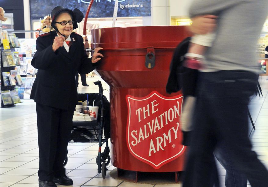 In this Nov. 15, 2014 photo, 92 year-old Salvation Army bell ringer Esther Rahenkamp, of Avon Park, Fla., greets shoppers at NorthPark Mall in Davenport, Iowa, standing next to a 700-pound donation kettle. Since 2001, Rahenkamp has lived in central Florida but comes back to the Quad-Cities each year with the help of Maj. Gary Felton, a good friend and local Salvation Army coordinator, to take up her post as bell ringer -- often as much as eight hours per day, six days per week. (AP Photo/The Dispatch, Gary Krambeck) QUAD CITY TIMES OUT